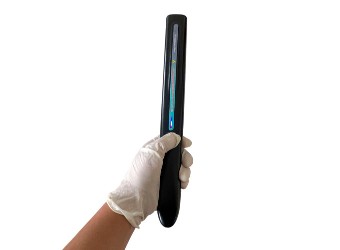 A person wearing a latex glove holding up a UV wand on a white background.